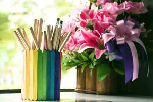 Closeup view of rainbow case which has various pencils inside, blurred nature ouside window background, concept for LGBT celebration in pride month and home decoration of LGBT people around the world. photo
