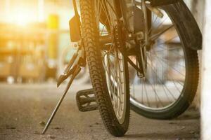 Closeup view of vintage bike which has flat wheels and parked on cement floor of downstairs of the building, soft focus. photo