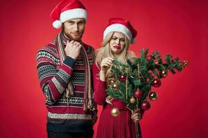man and woman christmas toys holiday decoration red background photo