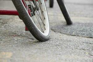 un antiguo bicicleta cuales tiene plano llantas y estacionado por el urbano la carretera y esperado a reparar o a cambio el nuevo uno y a rellenar el aire adentro, suave enfocar. foto