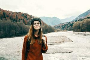 portrait of woman traveler in mountains outdoors near river landscape cropped view photo