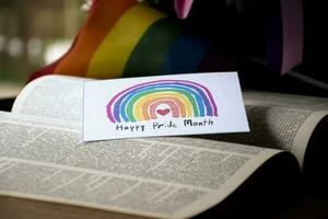 'Happy Pride Month' card on opened book, concept for calling out to respect gender diversity and to invite all people to enjoy LGBTQ events celebrations around the world in pride month. photo