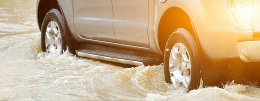 Closeup view of the rear wheel of a black pickup truck that was passing through a flood, car insurance and car fixing concept. photo