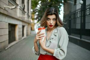 rubia mujer en rojo falda al aire libre taza de café divertido foto