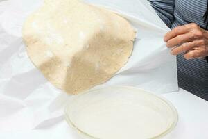 Transferring the quiche Lorraine dough to the glass baking dish photo