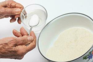 Colombian arepa dough preparation. Add salt to warm water photo