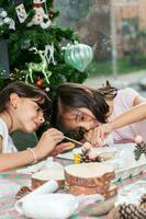 Two little sisters having fun while making christmas Nativity crafts with at home - Real family photo