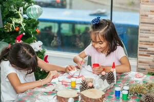 Two little sisters having fun while making christmas Nativity crafts with at home - Real family photo