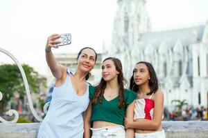 Tourists taking a selfie at the Ortiz Bridge with La Ermita church on background in the city of Cali in Colombia photo