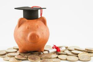 Piggy bank with graduation cap isolated on white background. Saving money to study concept photo