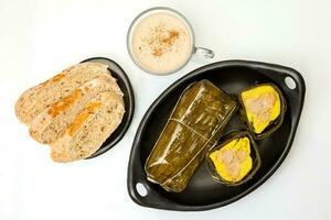 Traditional Colombian tamale breakfast with bread and chocolate as made on Santander region isolated on white background photo