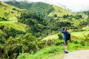 Tourist taking pictures at the beautiful Valle de Cocora located in Salento at the Quindio region in Colombia photo