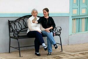 Senior mother and adult daughter traveling together at the beautiful small town of  Salento, located on the region of Quindio in Colombia photo