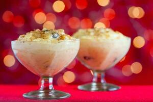 tradicional Colombiana postre hecho de arroz y Leche llamado arroz Delaware leche en un Navidad rojo antecedentes foto