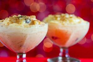 Traditional Colombian dessert made of rice and milk called arroz de leche on a christmas red background photo