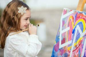 pequeño rubia niña pintura al aire libre foto