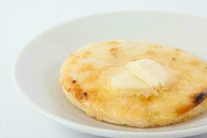 Traditional Colombian arepa topped with melted butter photo