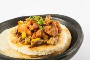 Colombian arepa topped with shredded beef and pork rind photo