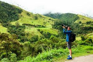 turista tomando imágenes a el hermosa valle Delaware cocora situado en salento a el quindio región en Colombia foto