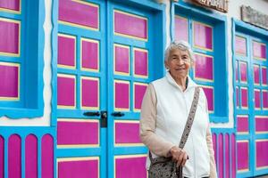 Senior woman at a traditional colorful street in the beautiful colonial town of Salento in Colombia photo