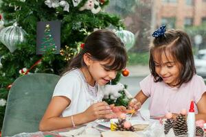 Two little sisters having fun while making christmas Nativity crafts with at home - Real family photo