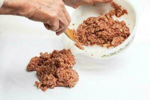 Preparation of a baked egg and vegetables stuffed meatloaf covered with bacon. Meat roll photo