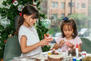 Two little sisters having fun while making christmas Nativity crafts with at home - Real family photo