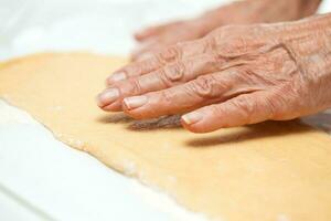 Closeup of woman hands stretching dough photo