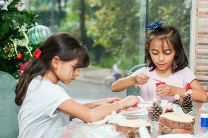 Two little sisters having fun while making christmas Nativity crafts with at home - Real family photo