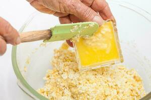 Traditional Colombian Arepa de Choclo Preparation. Adding melted butter photo