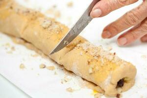 Cutting the rolled up strudel dough photo