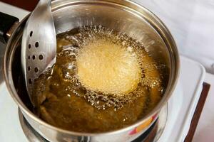 Preparation of the traditional dish from the Caribbean Coast in colombia called Arepa de Huevo or egg arepa photo