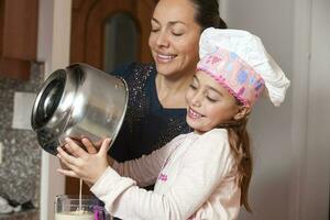 madre y hija teniendo divertido en el cocina horneando juntos. preparando magdalenas con mamá foto