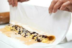 Strudel preparation. Rolling up the strudel photo