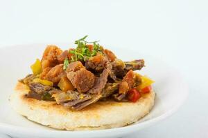 Colombian arepa topped with shredded beef and pork rind photo