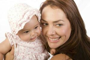 contento hermosa joven madre y su bebé niña en blanco antecedentes foto