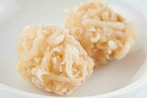 Colombian traditional coconut sweet called cocada in a white ceramic dish photo