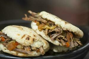 Colombian arepa filled with shredded beef photo