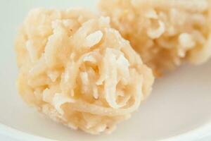 Colombian traditional coconut sweet called cocada in a white ceramic dish photo