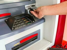 Close up of a man withdrawing money from an ATM photo