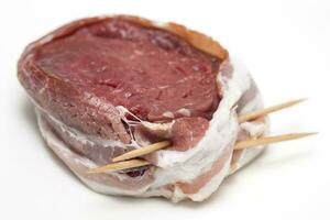 crudo carne de vaca filete de lomo medallón envuelto en Cerdo tocino. filete mignon preparación. foto
