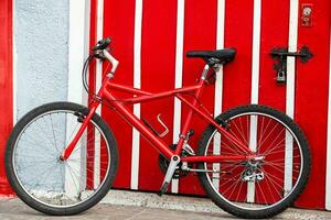 rojo bicicleta siguiente a un rojo puerta a el hermosa pequeño pueblo de filandia en el región de quindio en Colombia foto