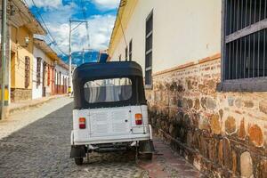 Traditional motorcycle at the beautiful antique streets of the colonial town of Santa Fe de Antioquia in Colombia photo