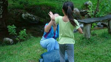 famille camping Extérieur, enfant portion mère garder le tente. mère et fille aller sur un aventureux vacances voyage ensemble. en bonne santé mode de vie et éco-tourisme. video