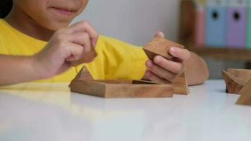 asiático linda pequeño niña jugando con de madera juguete rompecabezas rompecabezas pirámide en mesa. sano niños formación memoria y pensamiento. de madera rompecabezas son juegos ese incrementar inteligencia para niños. video