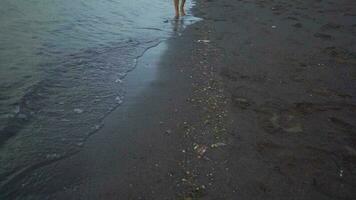 Man walk over the sea sand with sea wave. The footage is suitable to use for relaxion video background and travel content media.