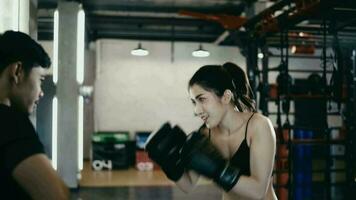 boxe allenatore formazione in forma bianca femmina pugile a Palestra nel lento movimento. barbuto istruttore nel guanti Lavorando con ragazza atleta. benessere, concorrenza, combattere, motivazione concetto video