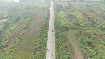 4K footage aerial view of the highway leading to residential areas between green fields. video