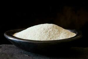 Maize flour in a traditional black clay dish. Zea mays photo