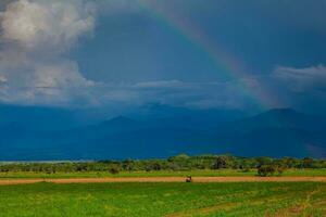 The rainbow over the cultivation fields and the majestic mountains of the Valle del Cauca region in Colombia photo